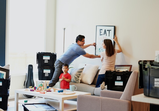 Family hanging pictures in new home